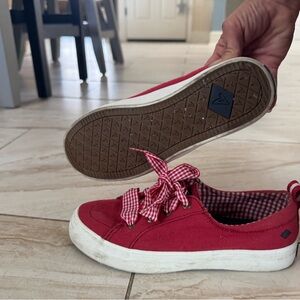 Worn red Sperrys with gingham laces.
